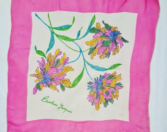 Könnte beinhalten: Ein weißer Seidenschal mit rosa Rand und einem Blumendesign. Die Blumen sind rosa, gelb, blau und grün. Der Schal trägt den Schriftzug "Christian Lacroix".