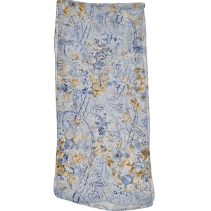 May include: A light blue fabric with a floral and paisley pattern. The design features shades of blue, white, and yellow. The fabric is likely used for bedding or home decor.
