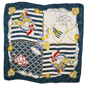 May include: A blue silk scarf with a nautical theme. The scarf features a repeating pattern of anchors, ropes, and ships' wheels. The scarf is trimmed with a gold chain.