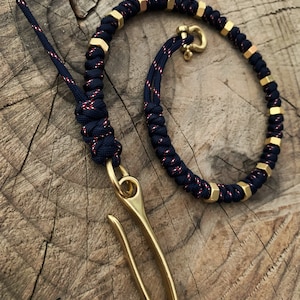 May include: A black and red paracord keychain with gold metal beads and a brass hook.