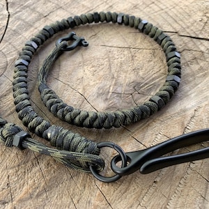 May include: A black and green paracord keychain with black metal beads and a black metal hook.