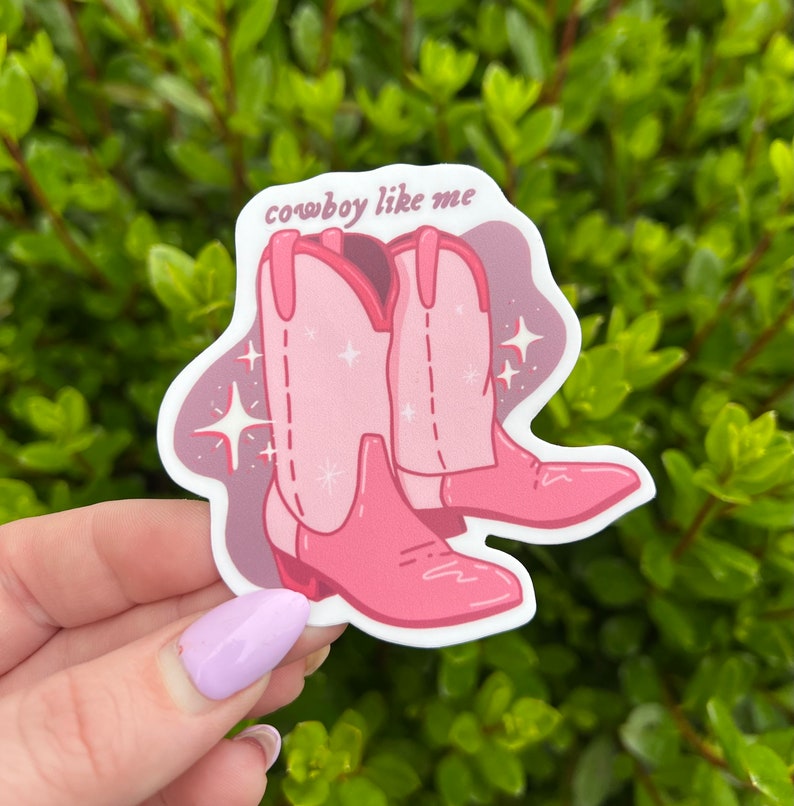 May include: Pink cowboy boots with glitter and the text "cowboy like me" on a sticker.