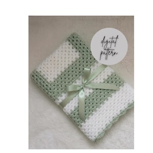 May include: A handmade crochet blanket in white and sage green, with a diagonal striped pattern. The blanket is tied with a sage green satin ribbon. The words "digital pattern" are in a circle in the upper right corner.