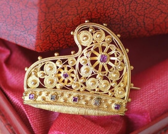 Spilla antica a forma di corno ducale con rubini e diamanti su oro giallo.