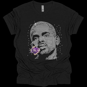 May include: Black t-shirt with a rhinestone design of a man's face. The design is in the center of the shirt and is surrounded by smaller rhinestones.