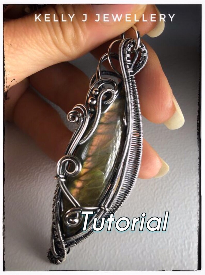 K&ouml;nnte beinhalten: Ein silberner, drahtgewickelter Anh&auml;nger mit einem gr&uuml;nen und schillernden Edelstein. Der Anh&auml;nger wird in einer Hand gehalten und das Wort "Tutorial" ist in der rechten unteren Ecke des Bildes sichtbar.