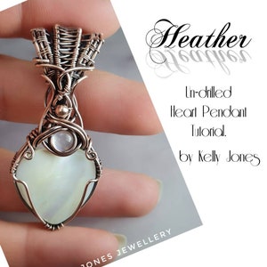 May include: A copper wire wrapped heart pendant with a white gemstone. The pendant is held in a hand. The text "Heather Un-drilled Heart Pendant Tutorial. by Kelly Jones" is in the background.