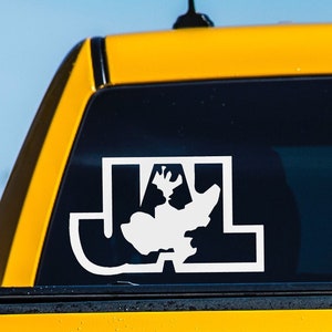 May include: White decal with the letters "JL" and a silhouette of a moose or elk. The decal is affixed to the black window of a yellow vehicle, with a blue sky in the background. The design is simple and bold.