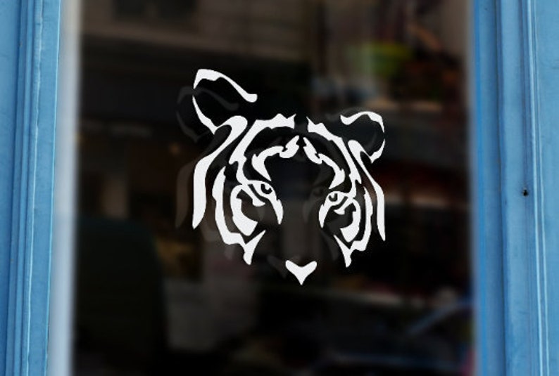 Puede incluir: Una silueta blanca de la cara de un tigre sobre un fondo negro. Los ojos del tigre est&aacute;n abiertos y la boca est&aacute; cerrada. Las rayas del tigre son visibles en la cara.