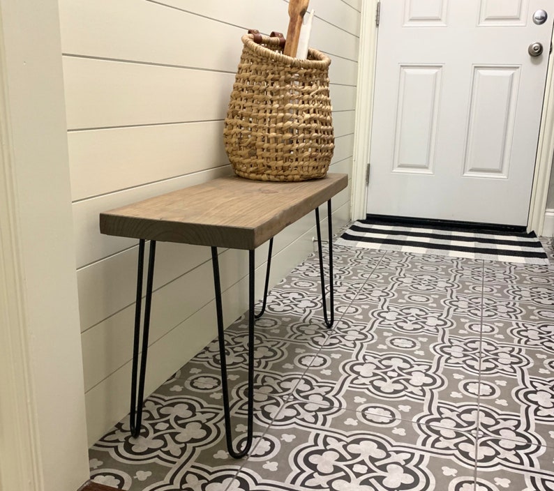 May include: A wooden bench with a natural finish and black hairpin legs. A woven basket sits on the bench, and the bench is placed on a patterned tile floor. The bench is approximately 36 inches long.