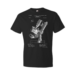 May include: Black t-shirt with a white vintage illustration of a microscope patent. The patent number is 611,827 and the date is February 2, 1899. The text reads "J. Bausch & Lomb Optical Co. Rochester, N.Y."