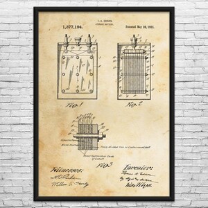 May include: A framed vintage print of a storage battery patent by T.A. Edison, dated May 10, 1921. The print features detailed technical drawings labeled Fig. 1, Fig. 2, and Fig. 3, with text including "Nickel Hydroxide or Oxide of Cobalt."