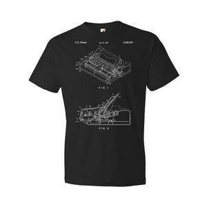 May include: Black t-shirt with a white print of a patent drawing for a keyboard. The patent number is 5,340,336 and the date is Aug. 25, 1992. The drawing shows two different views of the keyboard.