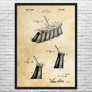 May include: Framed vintage print of a street push broom patent illustration. The print, dated June 9, 1936, features detailed diagrams and technical drawings of the broom's design, with the inventor's signature at the bottom.