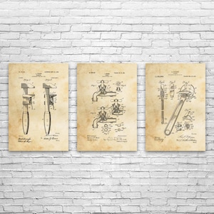May include: Three framed vintage patent prints of tools, including a wrench and a caliper, against a white brick wall. The prints are in sepia tones, showcasing detailed technical drawings and text.