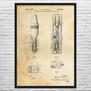 May include: A framed vintage patent print of a mortar training device and its components, dated February 4, 1958. The print features detailed technical drawings in black ink on a beige background, with multiple diagrams and text.