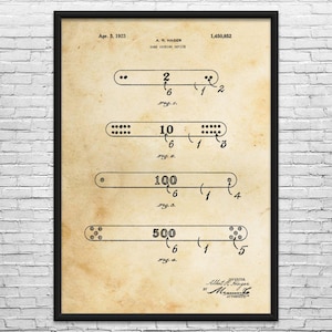 May include: Framed vintage patent print of a game scoring device, dated April 3, 1923. The sepia-toned print features detailed diagrams with numbers and dots, illustrating the device's scoring mechanism. The print includes the inventor's name and attorney's signature.
