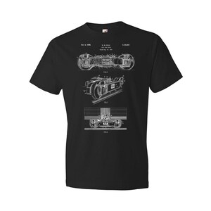 May include: Black t-shirt with a white print of a patent drawing for a railway car. The drawing shows the car's undercarriage and wheels. The patent number is 2,132,801 and the date is Oct. 4, 1938.
