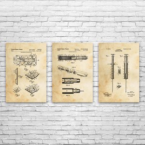 May include: Set of three vintage-style patent prints. The prints feature detailed technical drawings of medical devices, including a syringe and a blister pack. The prints are on a beige background with black ink, creating a classic, scientific aesthetic.
