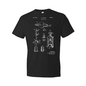 May include: Black t-shirt with a white print of a patent drawing for a "Cartridge Filling Device". The patent number is 2,008,712 and the date is Aug. 6, 1935.