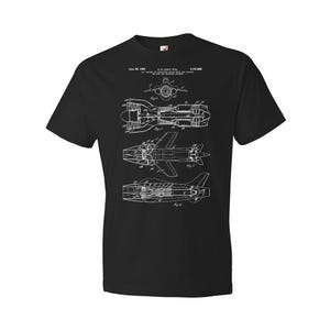 May include: Black t-shirt with a white print of a patent drawing for a jet aircraft. The patent number is 3,131,886 and the date is June 28, 1964. The drawing shows the aircraft in three different views.