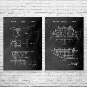 May include: Two black and white framed patent prints. The left print shows a diving board design with three figures. The right print shows a swimming pool design with two figures. Both prints are against a white brick wall.