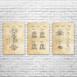 May include: Three vintage-style patent prints on aged paper, mounted on a white brick wall. Each print features detailed technical drawings with labels like "FIG. 1" and "FIG. 2", showcasing mechanical designs. The prints are framed and ready to hang.