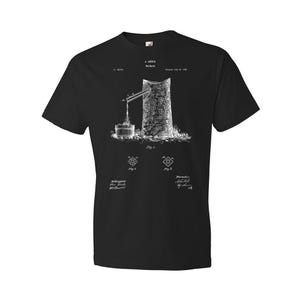 May include: Black t-shirt with a white print of a vintage patent drawing for a "Hop Spreader". The drawing shows a mechanical device with a hopper, a lever, and a spout. The text on the shirt reads "A. L. KAHLER Hop Spreader Patent July 10, 1888".