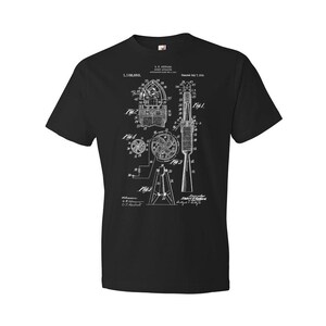 May include: Black t-shirt with a white print of a patent drawing for a rocket design. The patent number is 1,108,053 and the date is July 1, 1914.