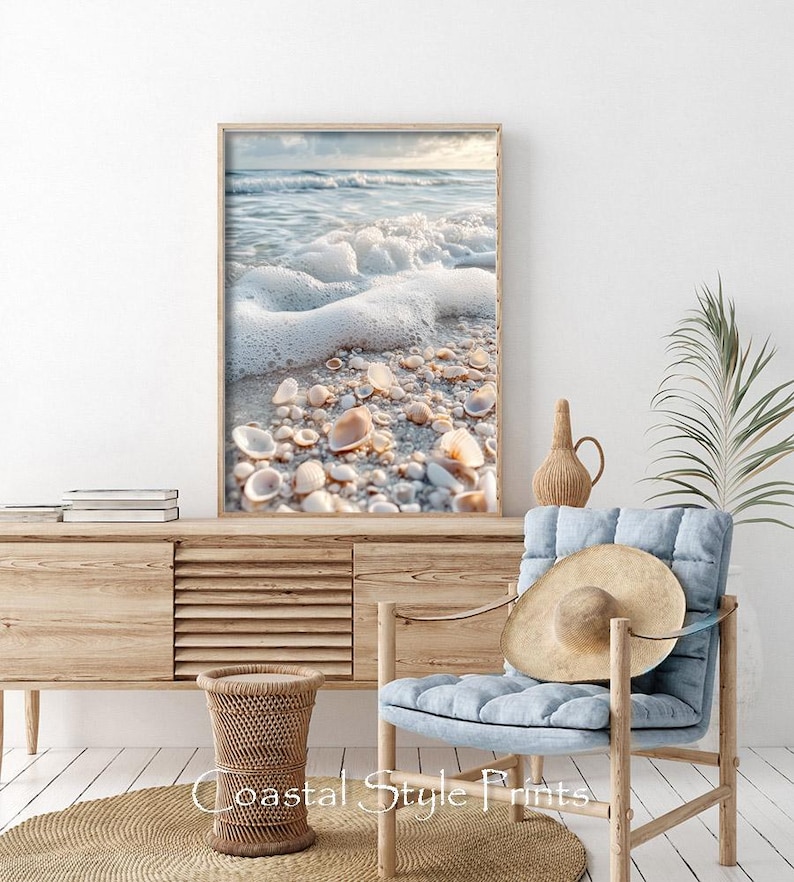 May include: A framed photograph of a beach scene with white foamy waves crashing on the shore. The sand is covered in seashells and the water is a light blue color.