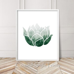 May include: A white framed print with a green watercolor lotus flower design. The lotus flower is filled with a foggy forest scene.