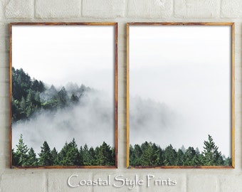 May include: Two framed prints of a misty forest scene. The prints are in wooden frames and feature a view of a forest with fog rolling through the trees.