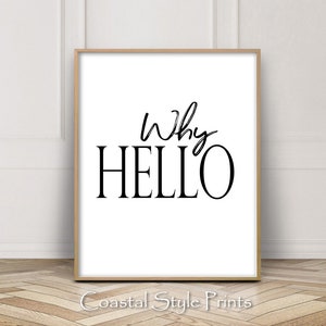 May include: A black and white printable wall art print with the text "Why Hello" in a modern calligraphy style. The print is framed in a light wood frame.