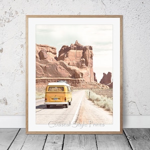 May include: A yellow vintage van drives down a road in a desert landscape with red rock formations in the background.