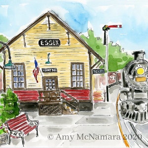 May include: Watercolor painting of the Essex train station with a steam engine. The station is yellow with red trim, an American flag, and the word "Essex" above the entrance. A red bench and a basket of flowers are in the foreground.