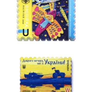 May include: Two Ukrainian postage stamps. The top stamp depicts a girl with butterfly wings flying in a blue sky with stars and an aeroplane. The bottom stamp shows a tank being towed by a tractor. Both stamps feature the text "Ukraina" and the year "2022".