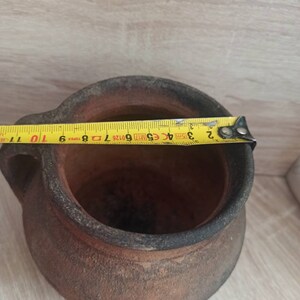 May include: A brown clay pot with two handles. The pot is 25 cm in diameter.