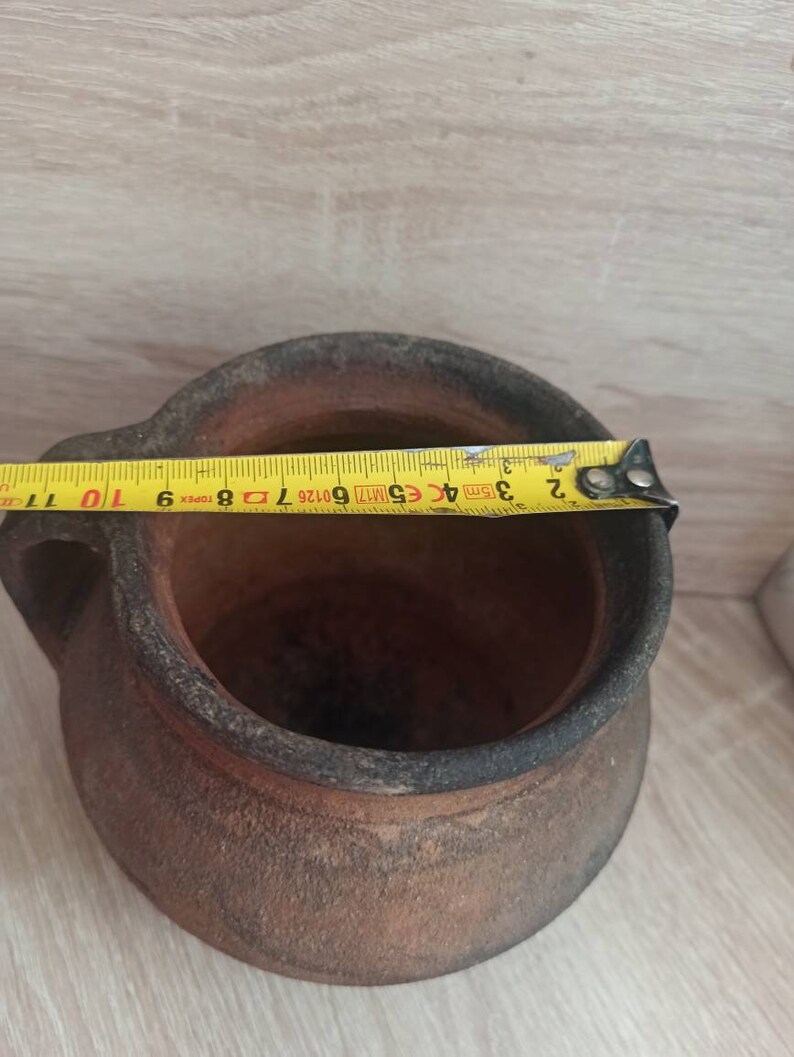 May include: A brown clay pot with two handles. The pot is 25 cm in diameter.