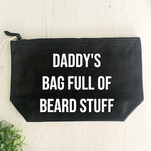 May include: Black canvas zippered pouch with white text that reads "Daddy's Bag Full of Beard Stuff".