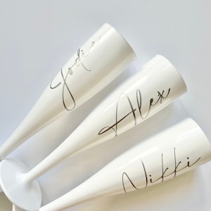 White personalised plastic champagne flutes for weddings, hen weekends or virtual hen do. Bride to be named glasses bridesmaids bride tribe