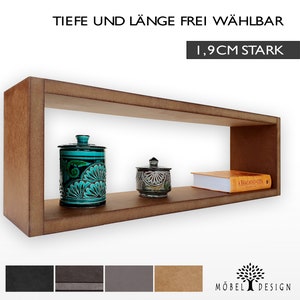 Op de afbeelding: Een bruine houten plank met een rechthoekige opening. De plank is 1,9 cm dik. De plank is leeg behalve voor een blauwe en groene keramische pot, een kleinere keramische pot met een deksel en een boek getiteld "A Bhagavad Gita".