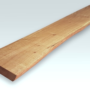 May include: A long, narrow piece of wood with a natural, live edge. The wood has a light brown color and a smooth, polished finish.