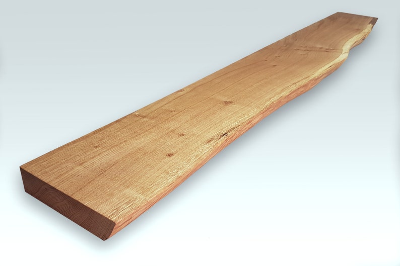 May include: A long, narrow piece of wood with a natural, live edge. The wood has a light brown color and a smooth, polished finish.