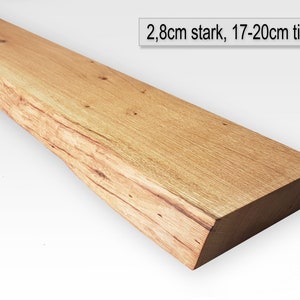 Può includere: Un lungo ripiano in legno naturale con un bordo grezzo. Il ripiano è spesso 2,8 cm e profondo 17-20 cm.