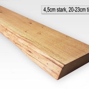 May include: A long, natural wood shelf with a rough-hewn edge. The shelf is 4.5 inches thick and 20-23 inches deep.