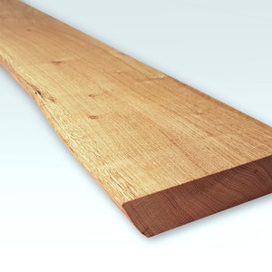 May include: A long, natural wood shelf with a live edge and a smooth, light brown finish. The shelf is approximately 24 inches long and 6 inches wide.