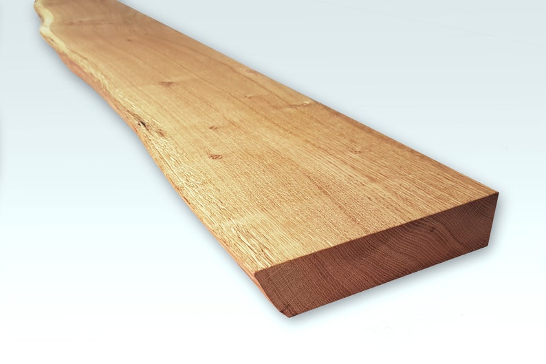 May include: A long, natural wood shelf with a live edge and a smooth, light brown finish. The shelf is approximately 24 inches long and 6 inches wide.