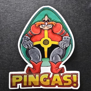 May include: A sticker featuring a cartoon character in a red and yellow outfit, with gray gloves and boots, set against a green background. The sticker has the word "PINGAS!" in bold, yellow letters.