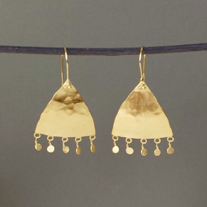 May include: Gold triangle earrings with a hammered texture and dangling circular charms.