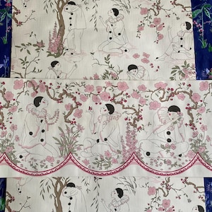 May include: Fabric featuring a repeating pattern of figures in white costumes with black buttons, set amongst pink blossom trees and foliage. The fabric has a scalloped edge with a pink border.